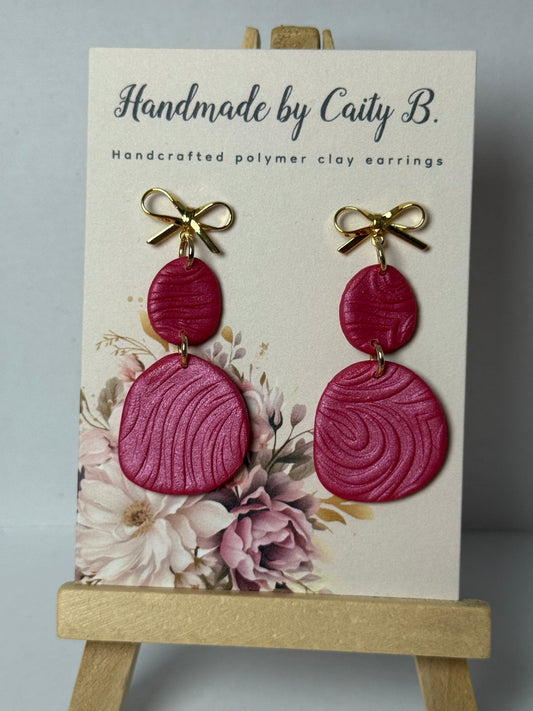 pink swirl earring with gold bows