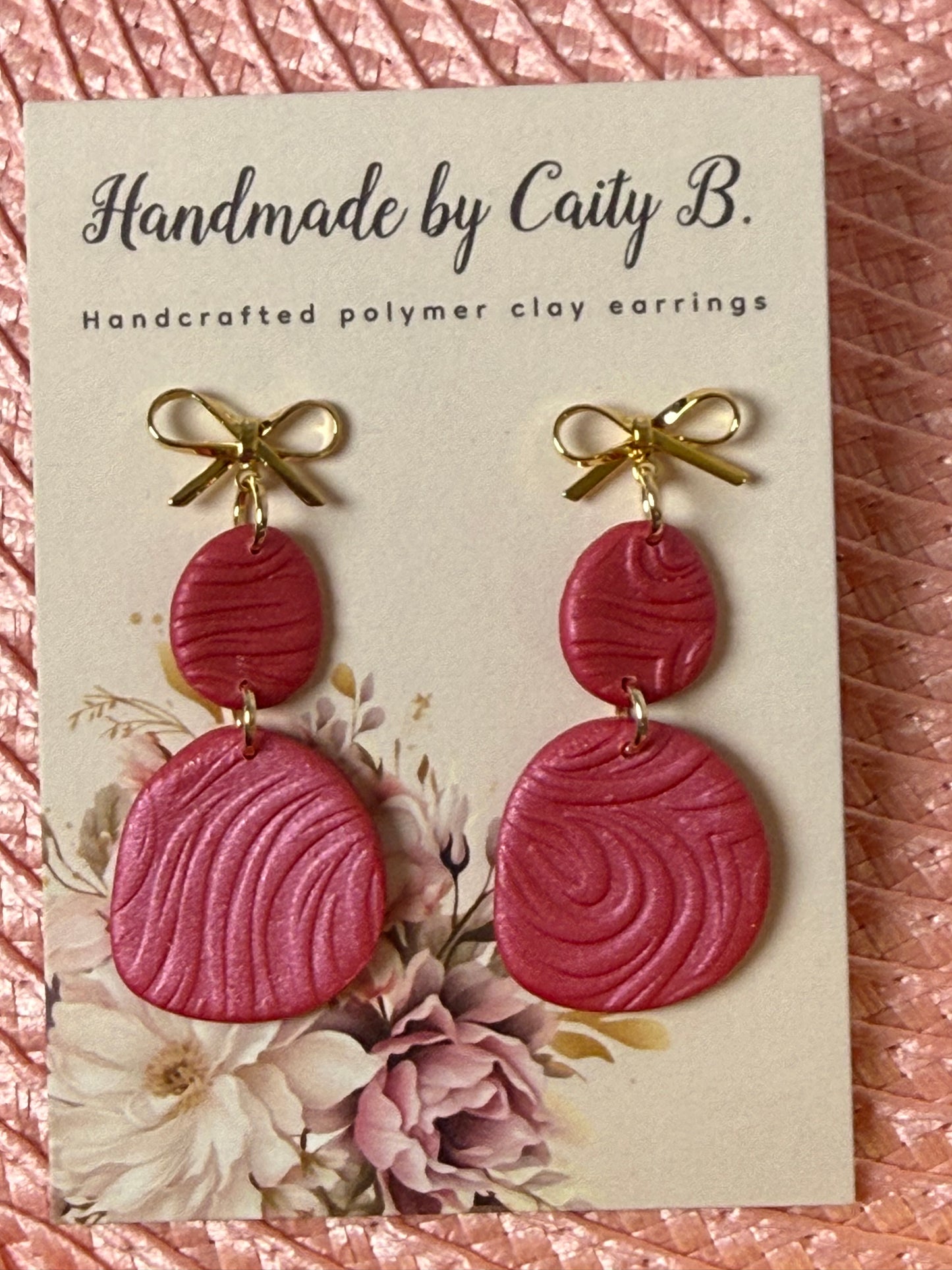 pink swirl earring with gold bows