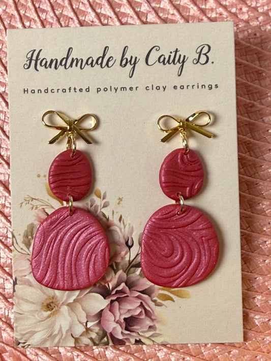 pink swirl earring with gold bows