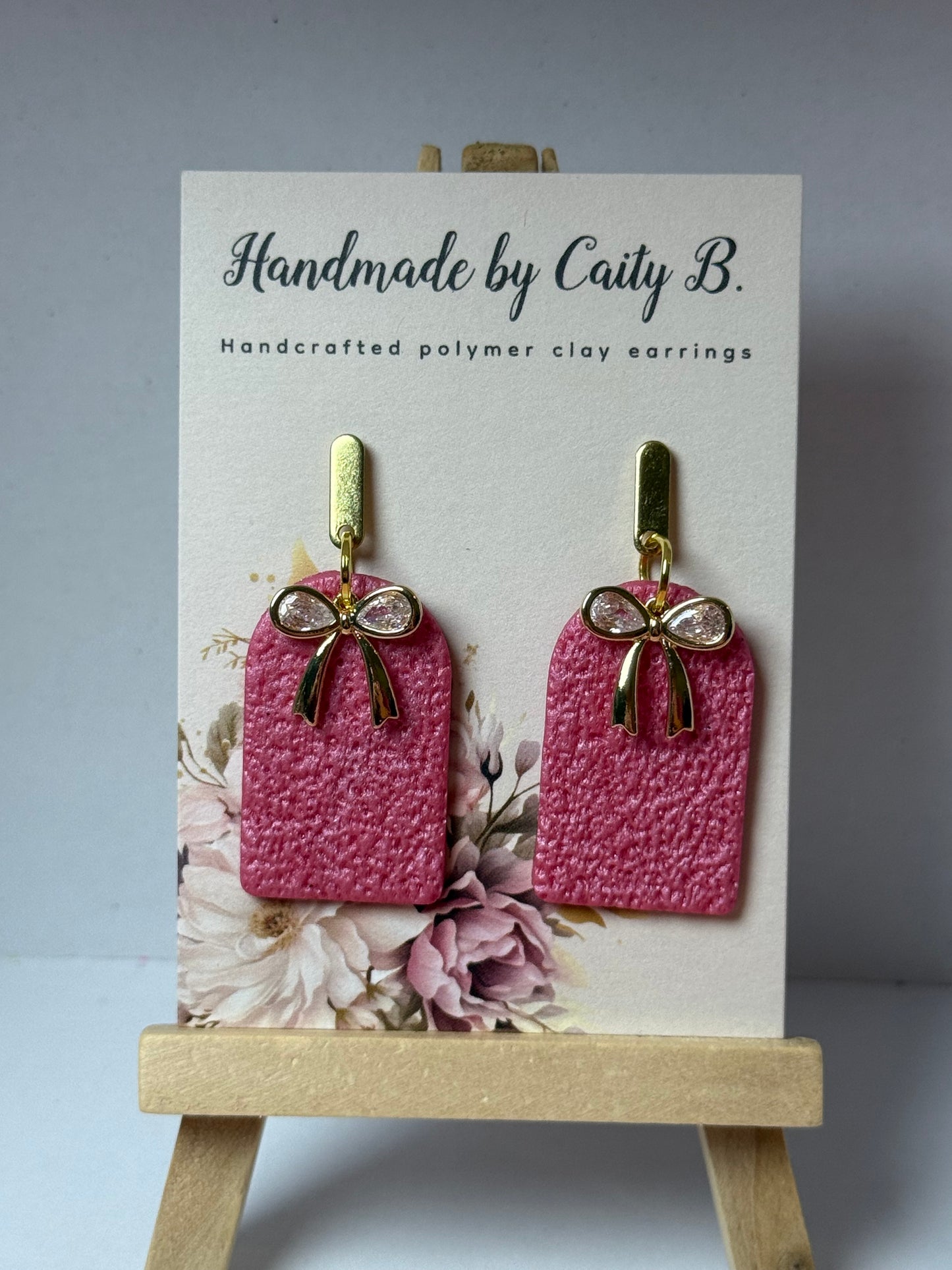 pink textured arch earrings with bow charms