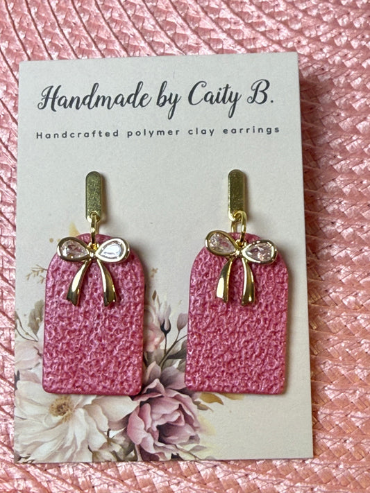 pink textured arch earrings with bow charms