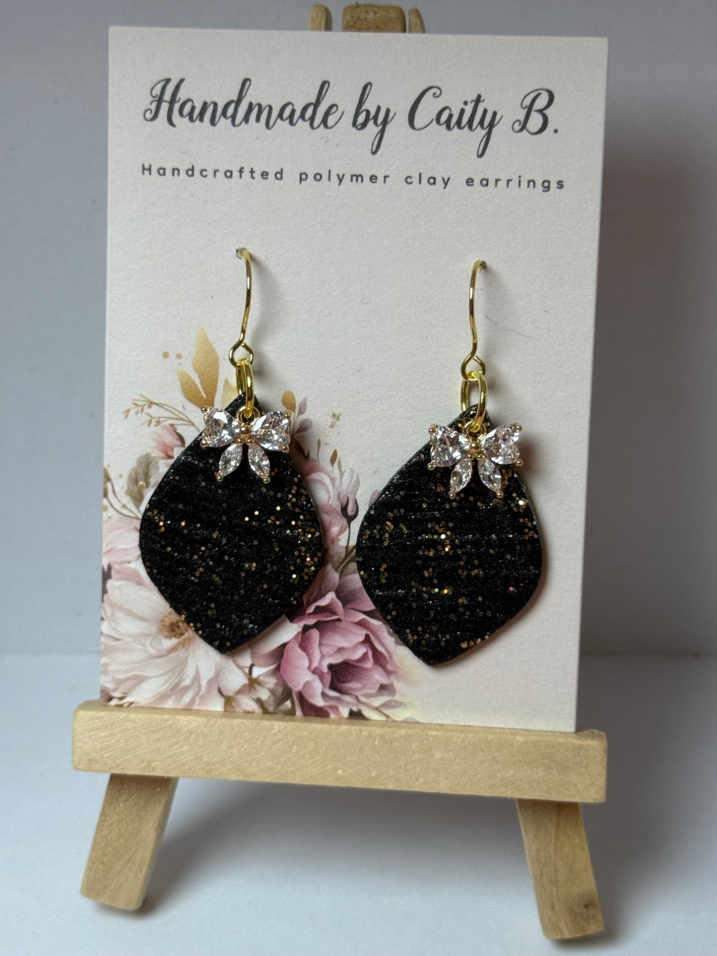 Sparkle black and gold drop earrings with bow charm